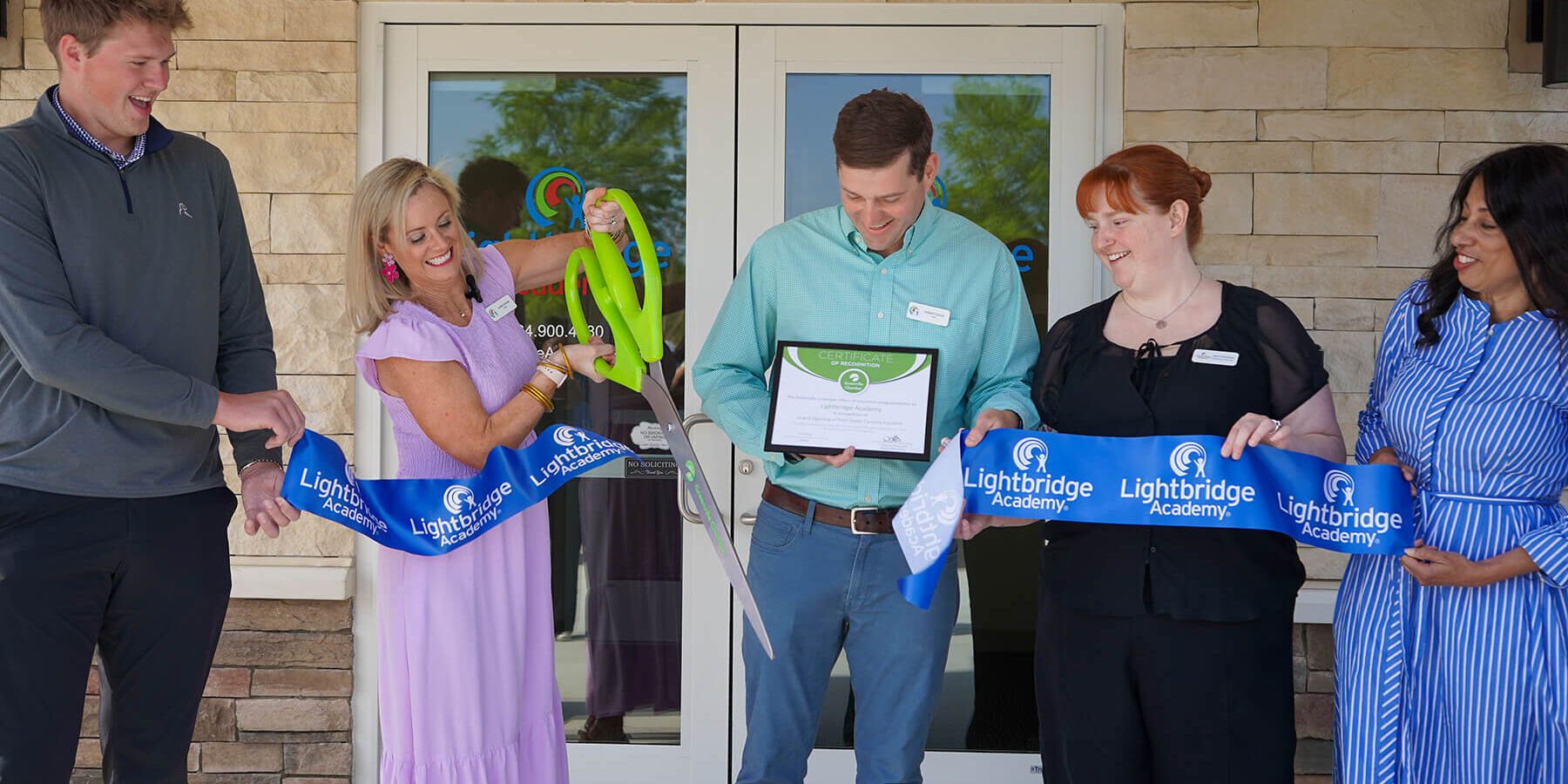 Ribbon cutting ceremony outside a business entrance