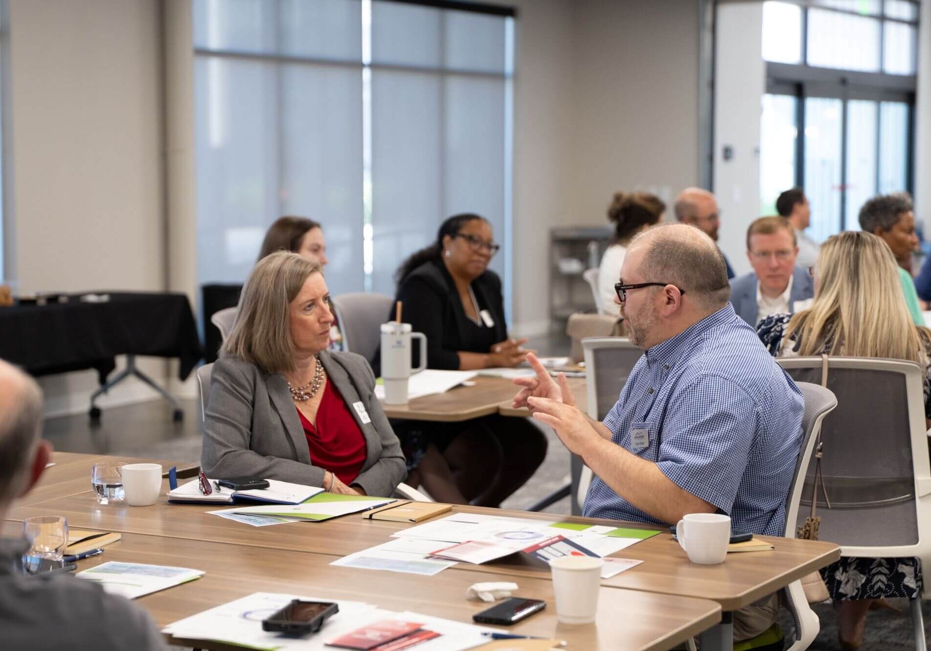 Attendees in discussion at tables during a working session